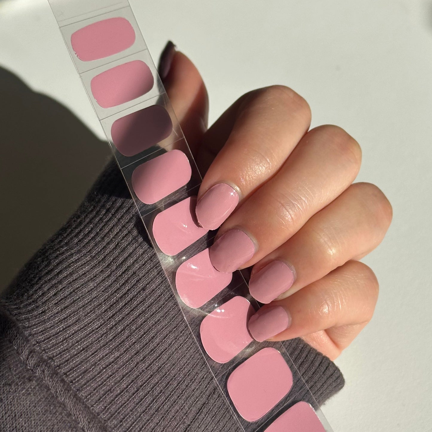 Nail polish color swatches with a hand holding them