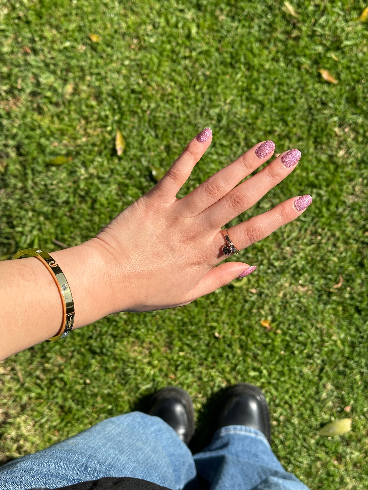 Hand with a ring on a grassy background