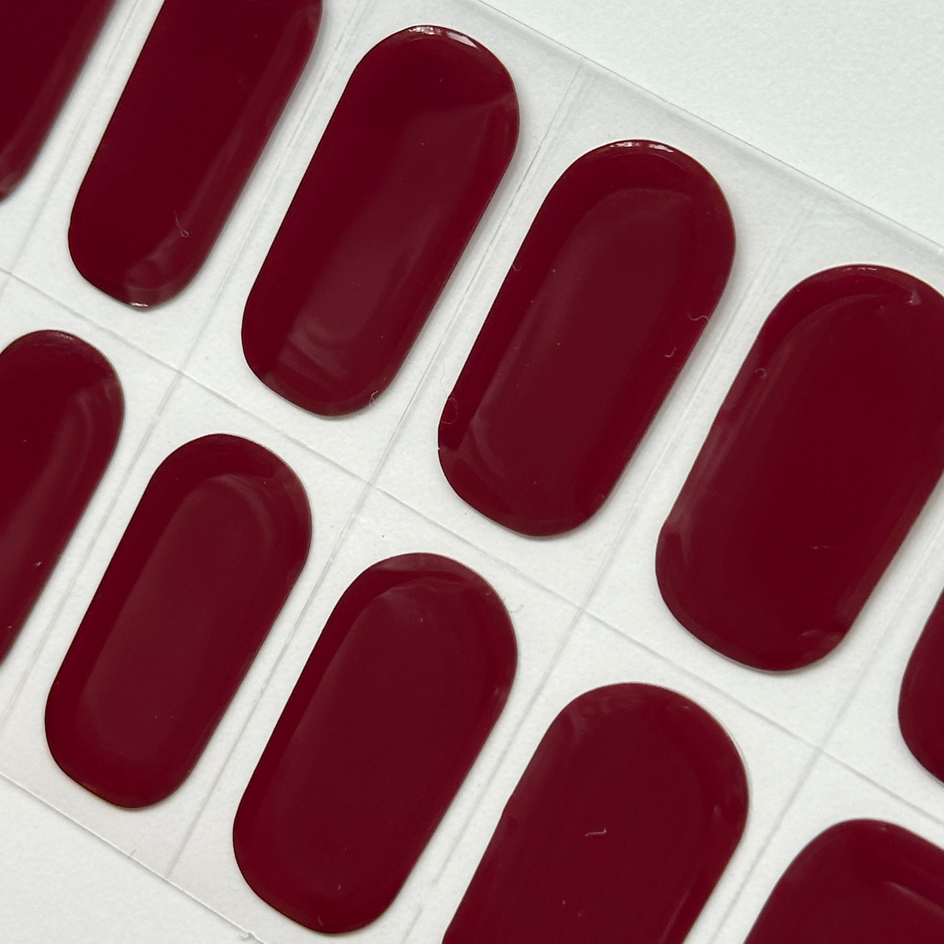 Sheet of red nail polish strips on a white background