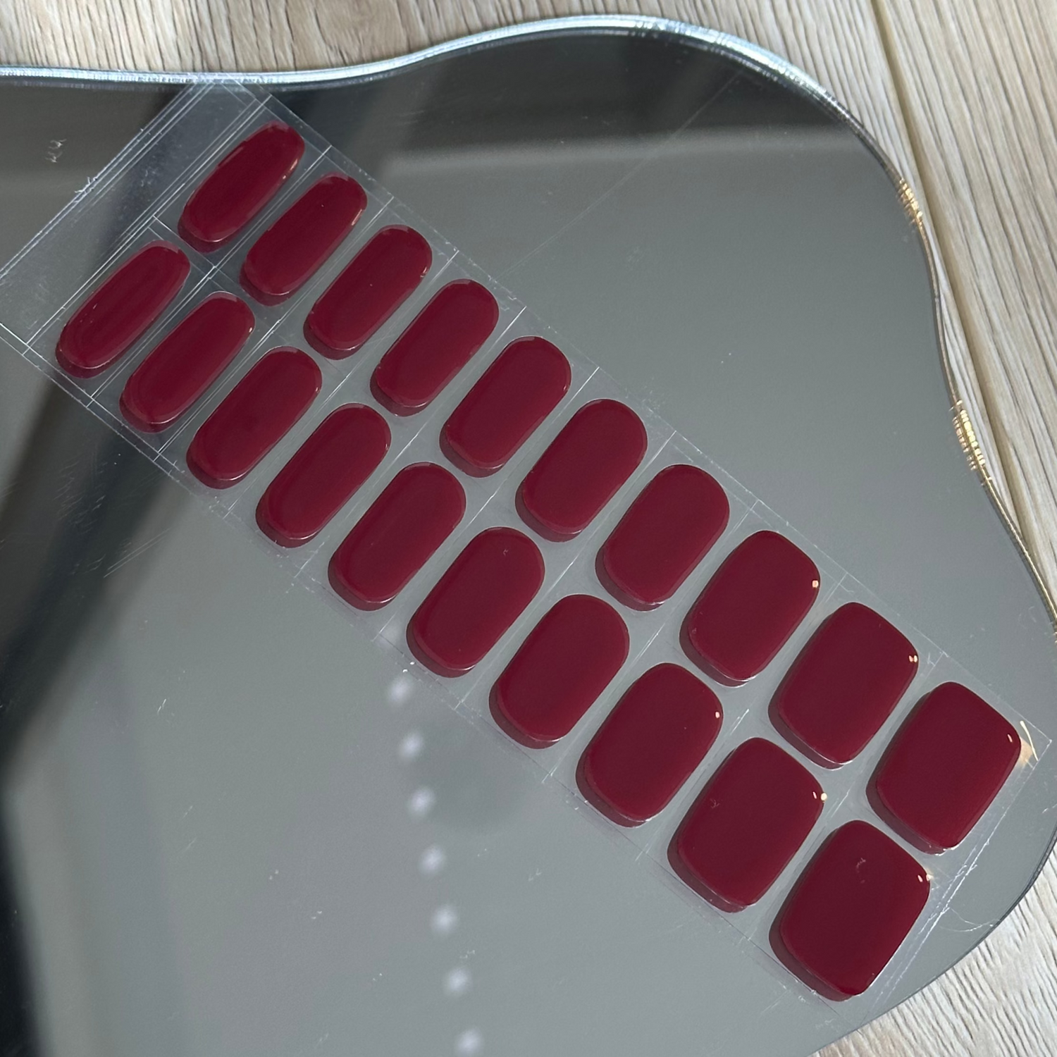 Metallic scoop with red rubber feet on a wooden floor