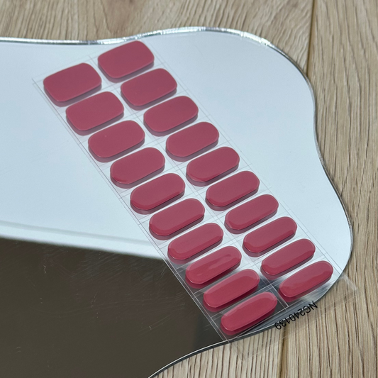 Metallic object with red rectangular pads on a wooden floor